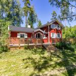 Rotes Holzhaus mit Terrasse und Umgebung im Wald