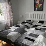 Schlafzimmer mit Doppelbett, Fenster und Wandbild.