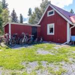 Rotes Holzhaus mit Fahrrädern und Sitzgruppe im Freien.