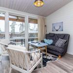 Wohnbereich mit Sofa, Sitzgelegenheiten und Blick auf Balkon.