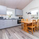 Küche mit Essbereich, Holztisch, Stühle und Küchengeräte.