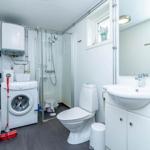 Badezimmer mit Dusche, Toilette, Waschmaschine und Waschbecken