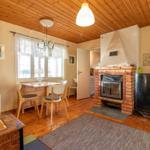 Wohnzimmer mit Kamin, Esstisch und Holzboden.