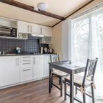Küche mit Esstisch, großem Fenster und modernen Schränken.