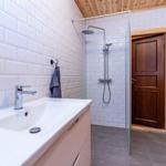 Bathroom with shower, sink, and wooden wall