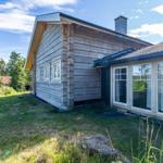 Wooden house with windows and roof under blue sky