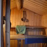 Sauna with wooden walls, benches, and towels