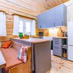 Kitchen with wooden walls, gray cabinets, and seating area with cushions.