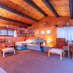 Living room with wooden walls, sofa, two chairs and table