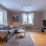 Wohnzimmer mit Sofa, Couchtisch und Fernseher an der Wand.