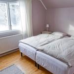 Schlafzimmer mit Doppelbett, Fenster und Holzboden.