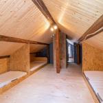 Attic room with wooden beds and wooden ceiling.