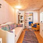 Living room with sofa, armchair, and wood-paneled walls. Hallway to another room.