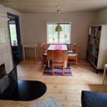 Dining room with wooden floor, table, chairs, and bookshelf.