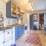 Kitchen with blue cabinets, wooden countertops, and red rug
