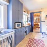 Kitchen with blue cabinets, wooden surfaces, and view into dining room.