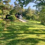 Haus mit großem Garten und Wald im Hintergrund.