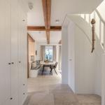 Eingangsbereich mit Treppe und Blick in Essbereich mit Tisch und Sitzbank.