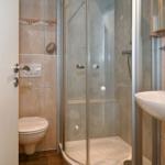 Badezimmer mit Dusche, Waschbecken und Toilette.