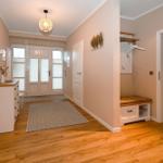 Eingangsbereich mit Holzboden, Schuhschrank und Garderobe. Durchgang zur Küche.