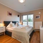 Schlafzimmer mit Bett, Nachttisch, TV und Fenster zur Außenseite.