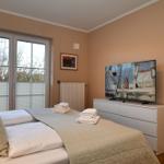 Schlafzimmer mit Doppelbett, TV und Fenster zur Außenseite.