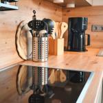 Küche mit Holzoberflächen, Kochutensilien und Kaffeemaschine.