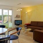 Wohnzimmer mit Sofa, Esstisch und Terrasse