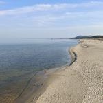 Strand mit Sand und Wasser unter blauem Himmel
