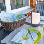 Tisch auf Balkon mit Platzset, Korb und Lampe