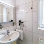 Badezimmer mit Waschbecken, Spiegel, Handtuch und Fenster.