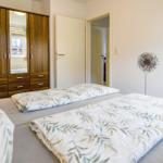 Schlafzimmer mit Doppelbett, Kleiderschrank und Wanddekoration.