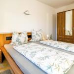 Schlafzimmer mit Doppelbett, Nachttisch und Kleiderschrank.