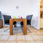 Essbereich mit Tisch, Stühlen und TV. Küche mit Arbeitsfläche und Küchenschränken.