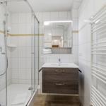 Badezimmer mit Dusche, Waschbecken und Heizkörper