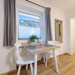 Essbereich mit Tisch, zwei Stühlen und Blick auf die Berge.