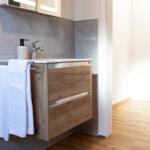 Badezimmer mit Waschbecken, Spiegelschrank und Duschabtrennung.