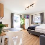 Schlafzimmer mit Bett, Esstisch, TV und Fenster mit Blick.