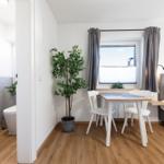 Schlafzimmer mit Bett, Tisch und Stühlen. Nebenraum mit Bad und Toilette.