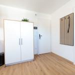 Eingangsbereich mit Kleiderschrank, Küchenzeile und Garderobe an der Wand.