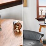 A table with a beer bottle and dice next to a window and a chair.