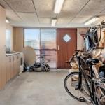Vaulted room with kitchenette, bicycles, and garden tools on the wall.