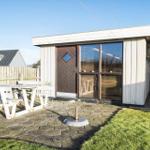 House with patio, white picnic table, wooden door, and windows with blinds.