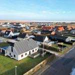 House with garden and view of coastal landscape with other houses.