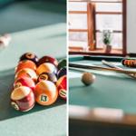 Billiard table with colored balls and cue. Window and plant in background.