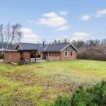 Ein Haus mit Garten und Spielplatz in einer ländlichen Umgebung.
