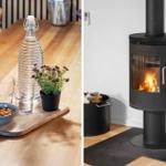 Holztisch mit Wasserglas, Nüssen und Pflanze. Kaminofen mit brennendem Feuer.