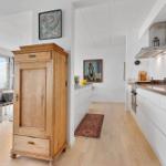 Kitchen with white cabinets and view to terrace with sea view.