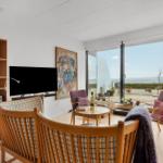 Living room with sea view, wooden furniture and TV.