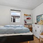 A bedroom with bed, dresser, shelf, and window. A world map is on the dresser.